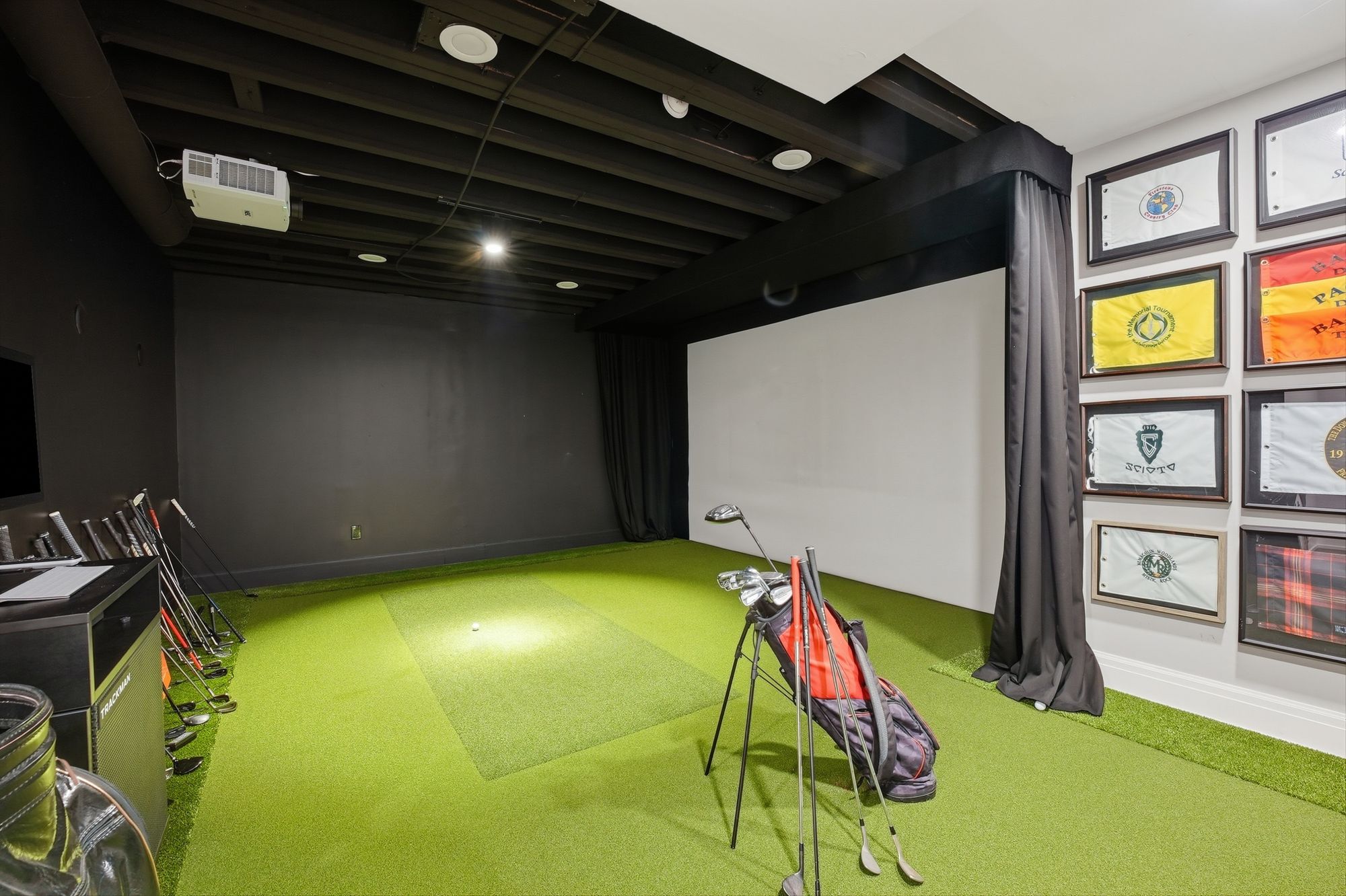 Golf simulator room with framed flag wall